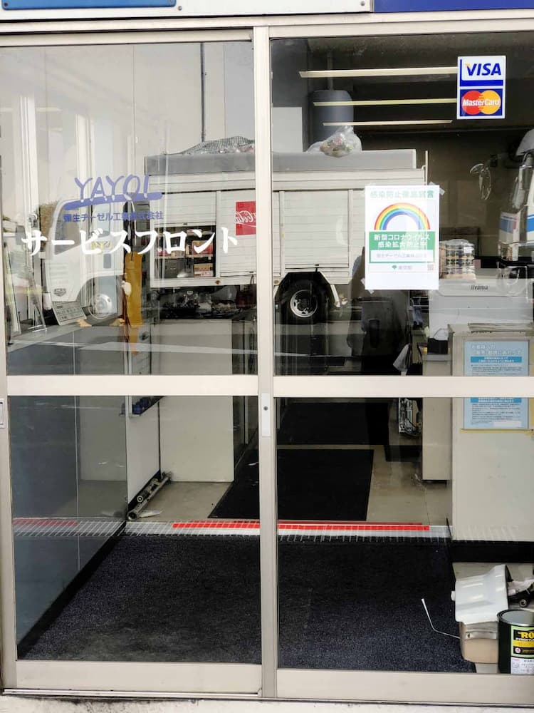 彌生ヂーゼル工業のサービスフロント入り口。感染防止対策ステッカーが掲示してある